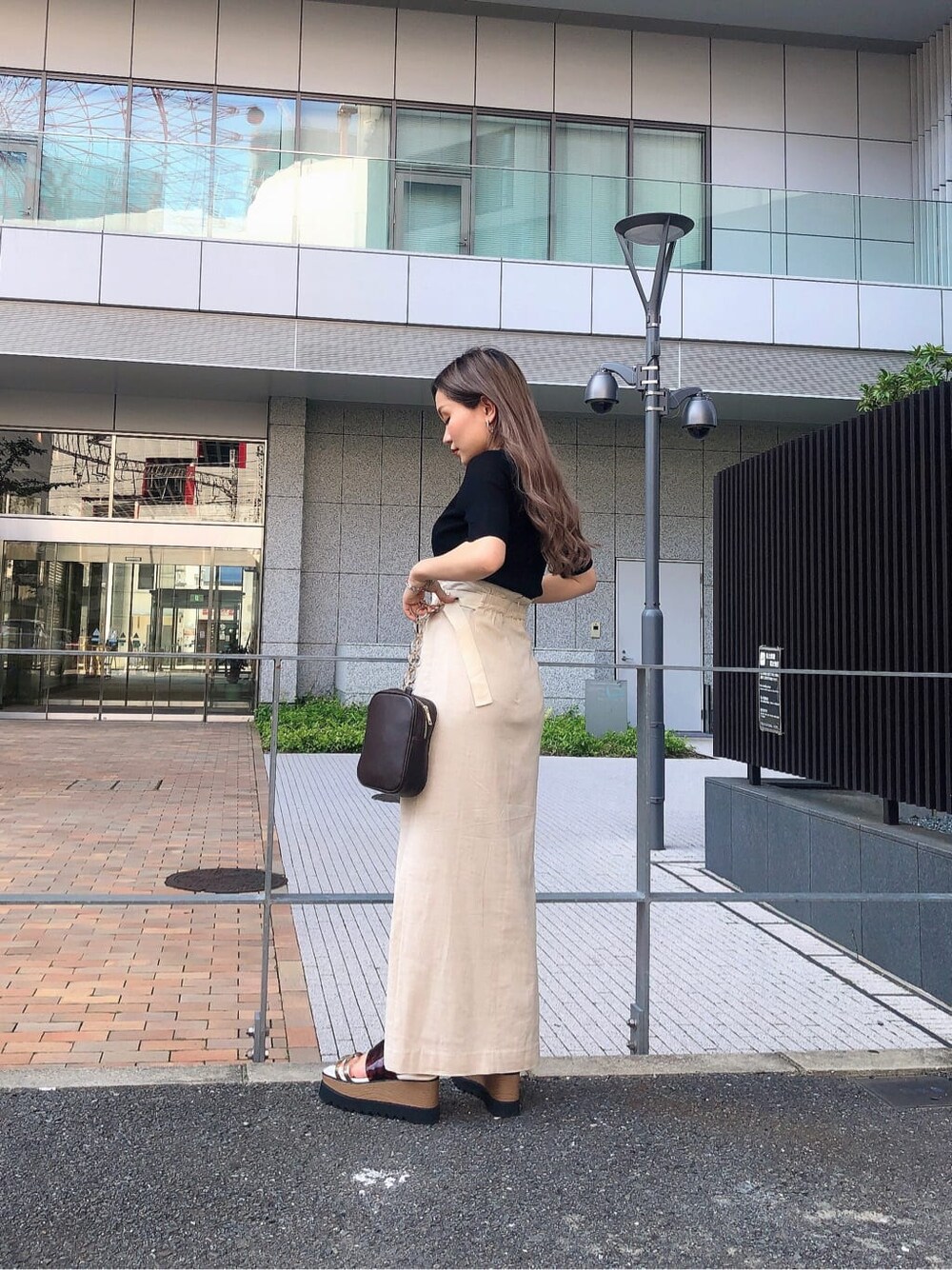 ホワイト系のスカート、その他のサンダル、ブラック系のニット/セーターを着用したレディースの夏コーディネートの2枚目の写真