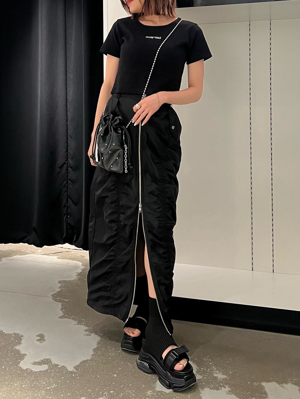 ブラック系のTシャツ/カットソー、ブラック系のサンダル、ブラック系のスカートを着用したレディースの春コーディネートの8枚目の写真