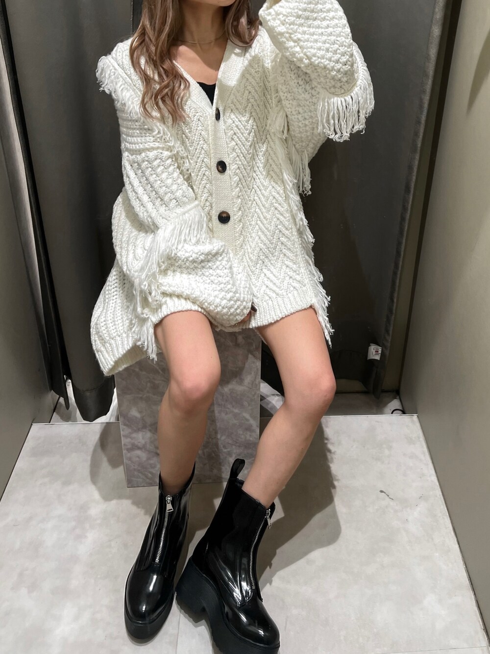 ホワイト系のカーディガン/ボレロ、ブラック系のスウェットパンツ、ブラック系のブーツを着用したレディースの冬コーディネートの4枚目の写真