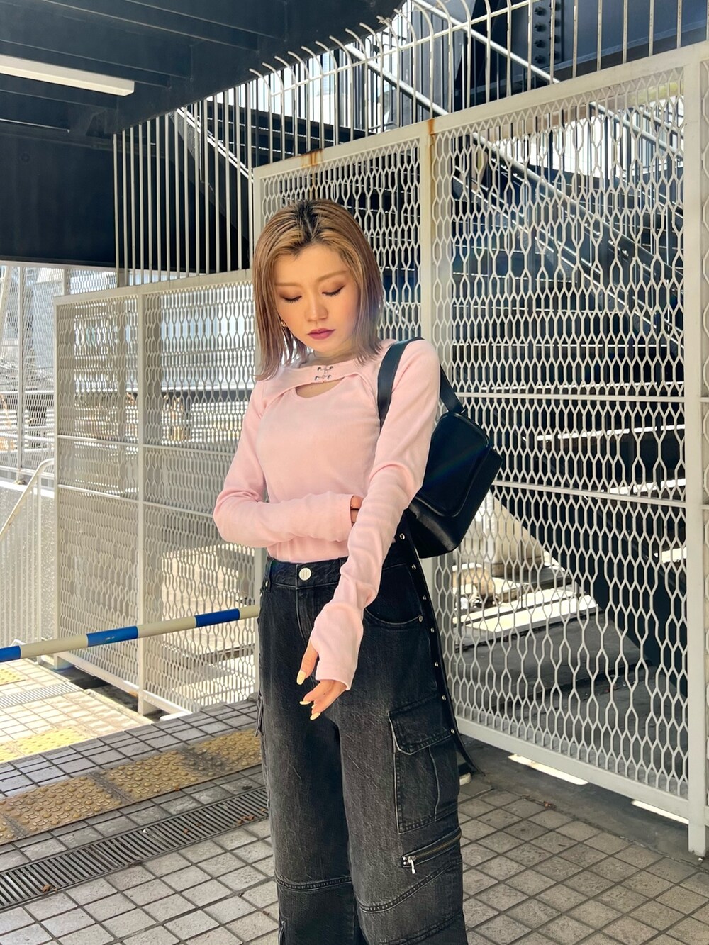 ピンク系のTシャツ/カットソー、ブラック系のデニムパンツ、ホワイト系のブーツを着用したレディースの冬コーディネートの7枚目の写真