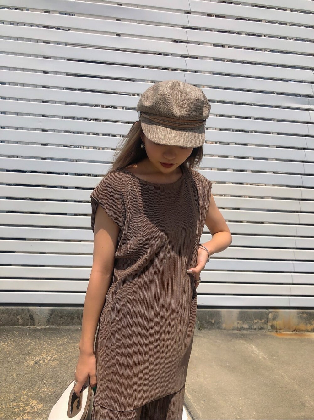 ベージュ系のシャツ/ブラウス、ブラウン系のハンドバッグ、ホワイト系のサンダルを着用したレディースの夏コーディネートの4枚目の写真