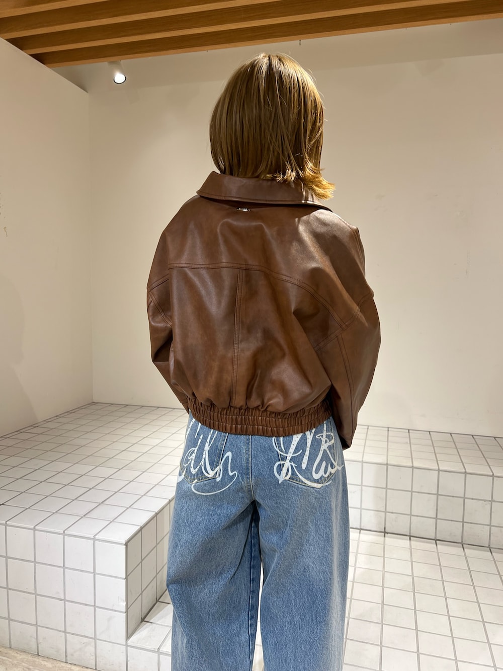 イエロー系のTシャツ/カットソー、ブルー系のその他パンツ、ブラウン系のブルゾンを着用したレディースの冬コーディネートの6枚目の写真