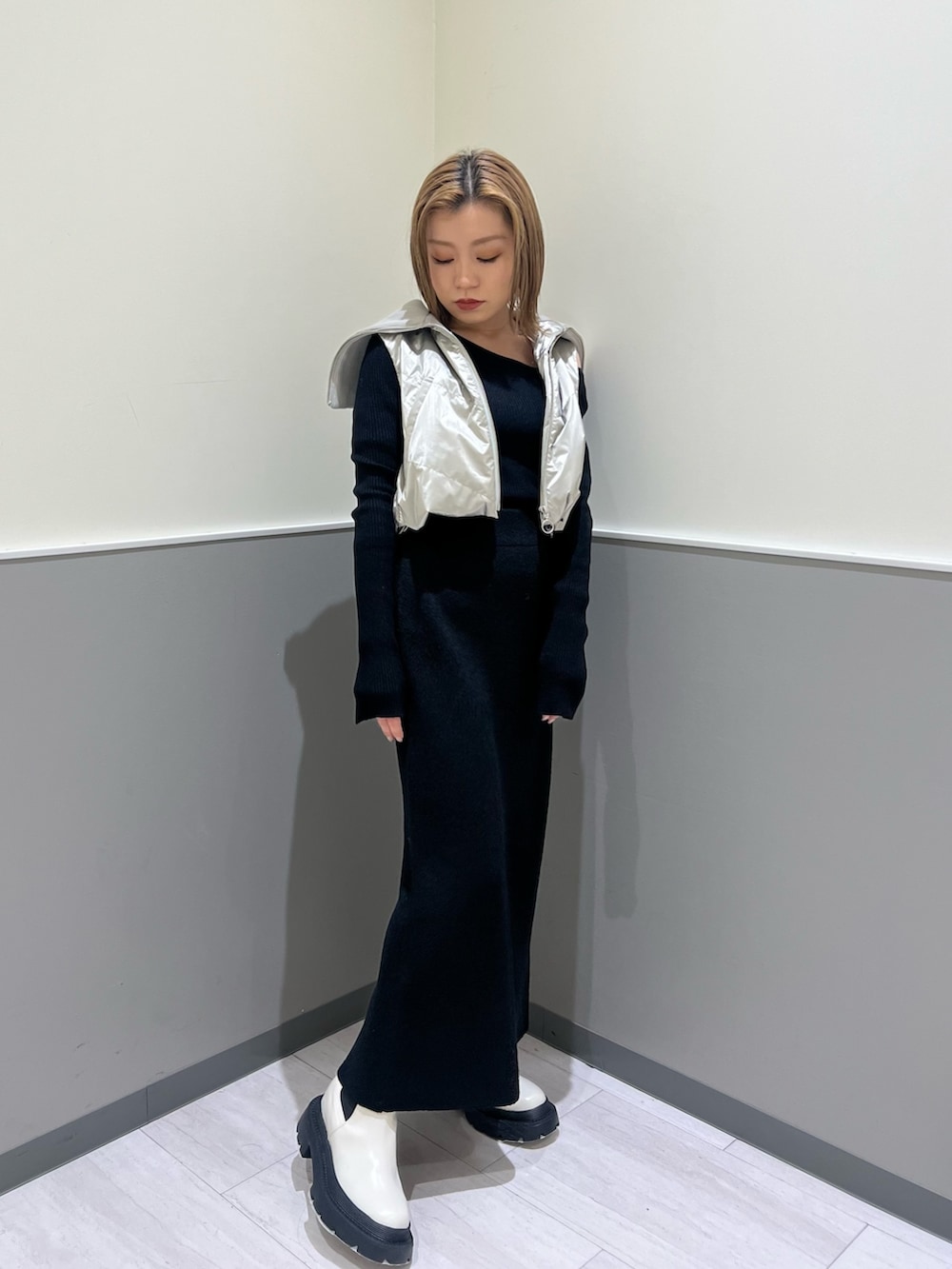 ホワイト系のブーツ、ブラック系のスカート、シルバー系のブルゾンを着用したレディースの冬コーディネートの4枚目の写真