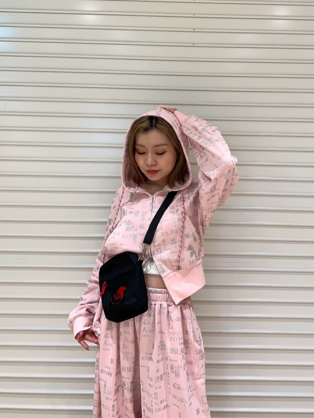 ピンク系のセットアップ、ブラック系のショルダーバッグを着用したレディースの春コーディネートの4枚目の写真