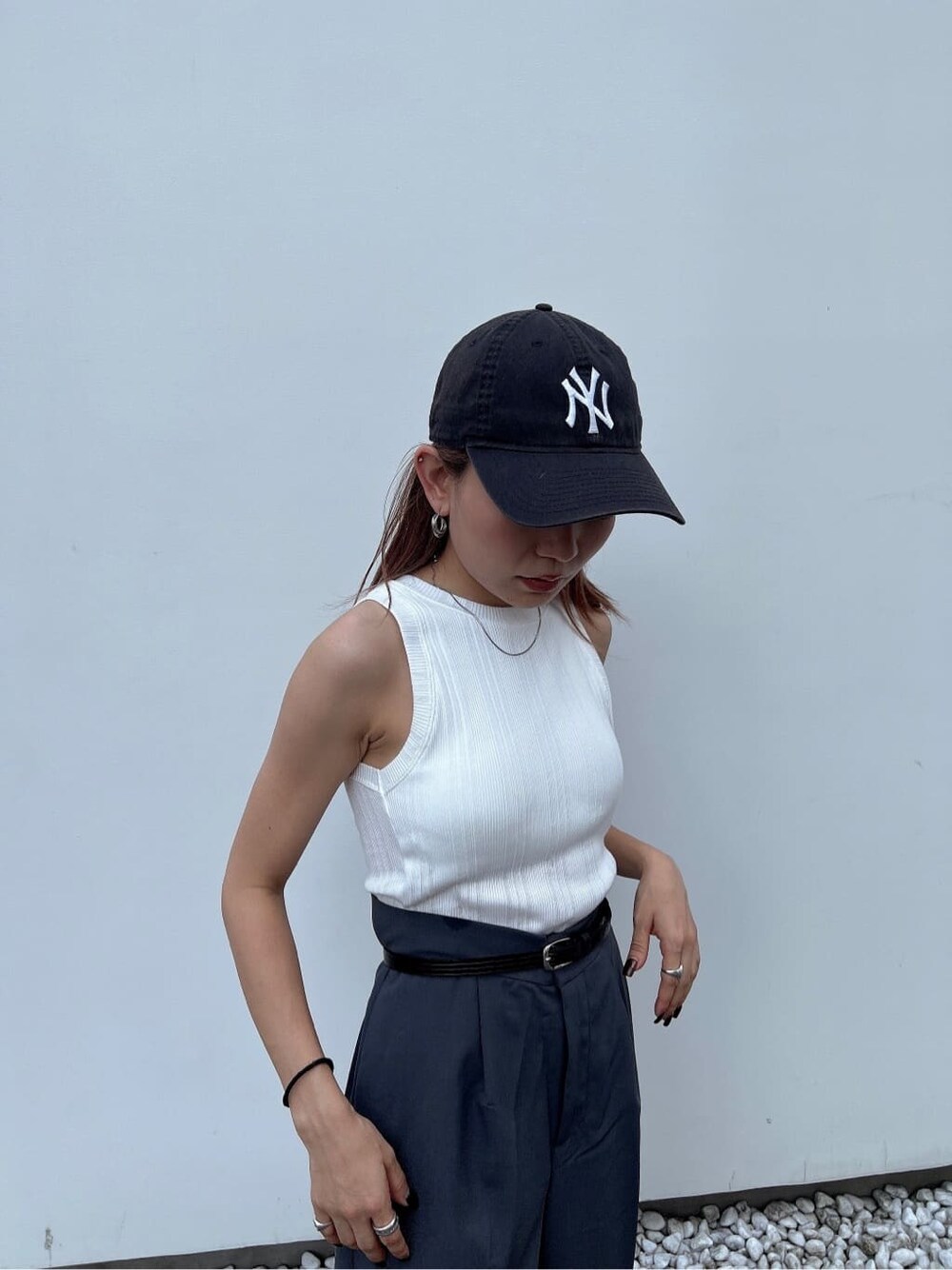 ホワイト系のタンクトップ、グレー系のスラックス、ブラック系のベルトを着用したレディースの夏コーディネートの7枚目の写真