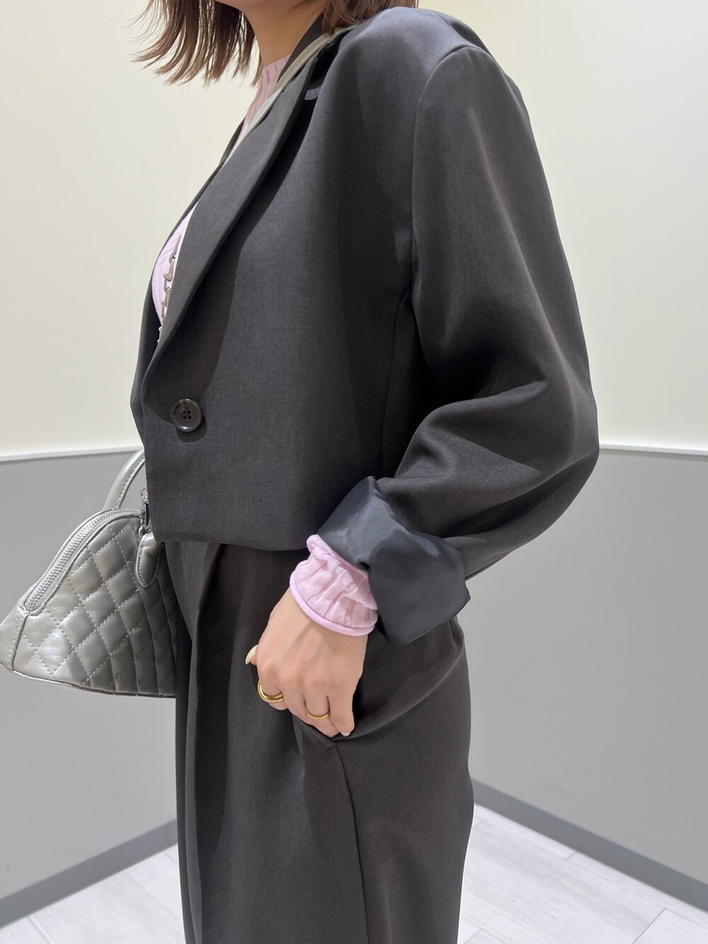 グレー系のテーラードジャケット、グレー系のその他パンツ、シルバー系のハンドバッグを着用したレディースの冬コーディネートの7枚目の写真