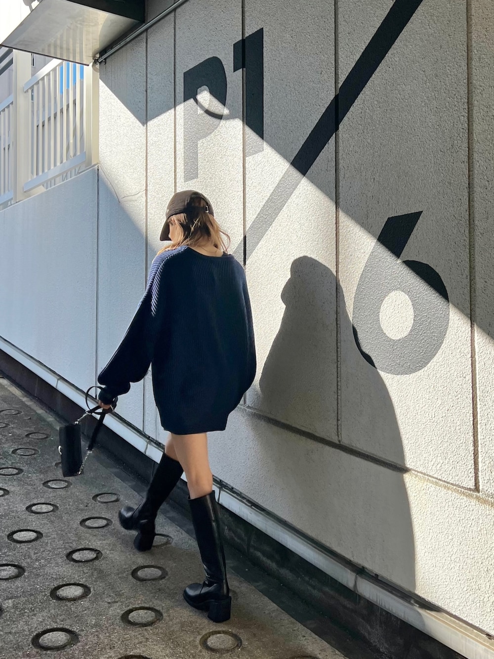 ブルー系のニット/セーター、グレー系のスウェットパンツ、ブラック系のブーツを着用したレディースの冬コーディネートの2枚目の写真