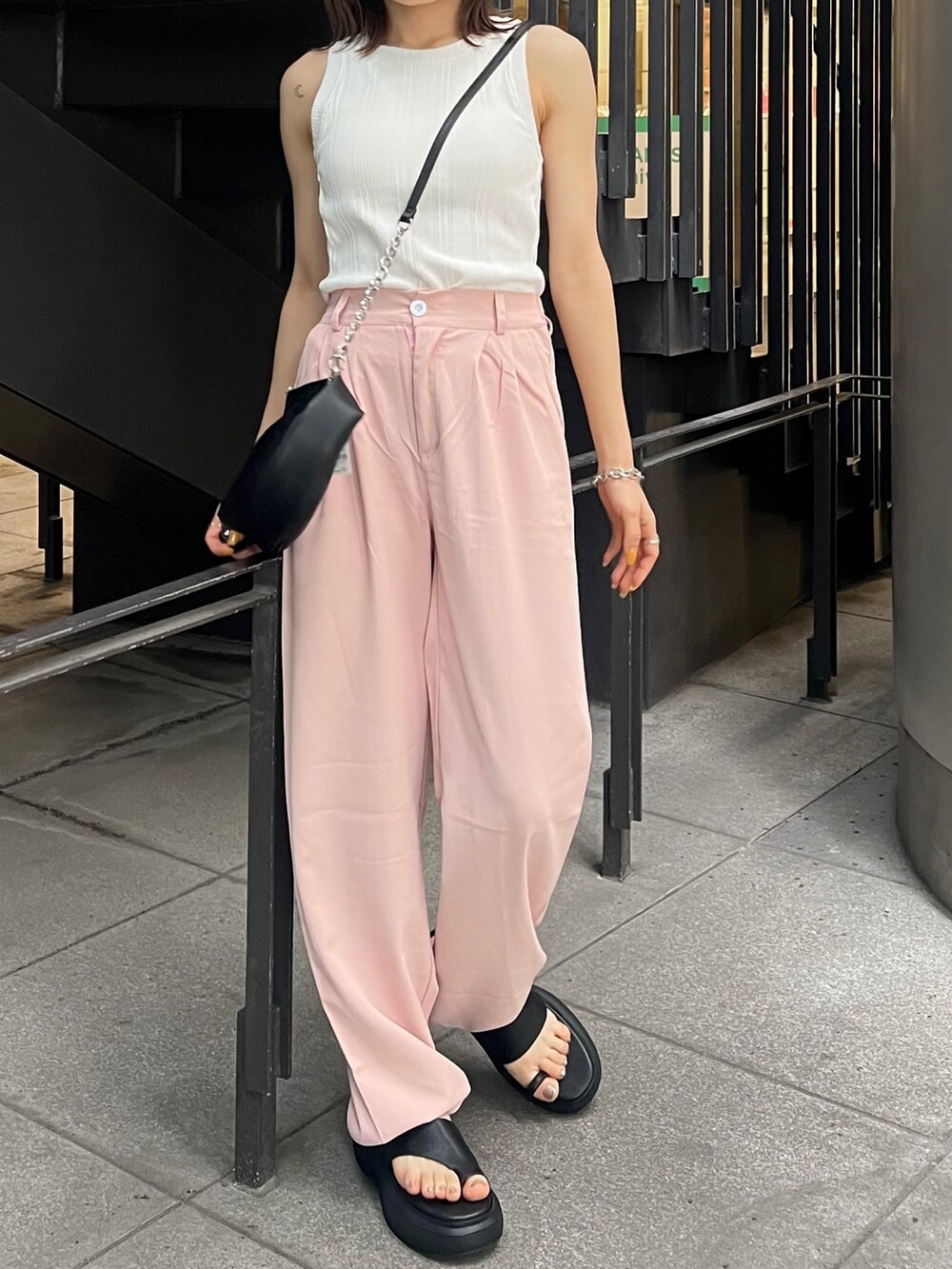 ブラック系のサンダル、ブラック系のハンドバッグ、ホワイト系のTシャツ/カットソーを着用したレディースの夏コーディネートの5枚目の写真