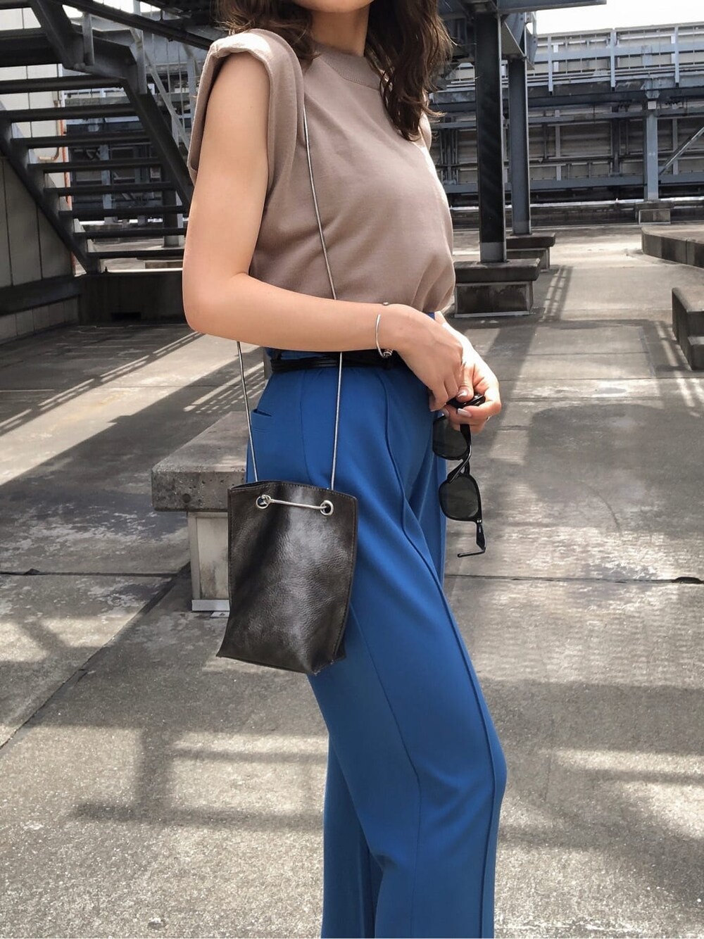 ブルー系のスラックス、ブラック系のサンダル、ベージュ系のタンクトップを着用したレディースの夏コーディネートの6枚目の写真