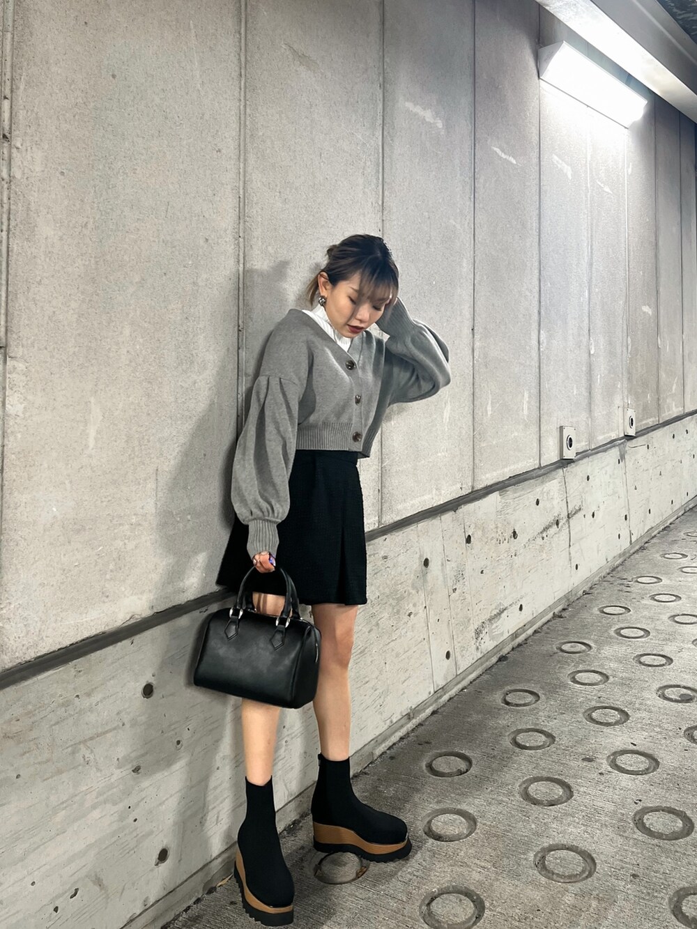 グレー系のカーディガン/ボレロ、ブラック系のブーツ、ホワイト系のニット/セーターを着用したレディースの冬コーディネートの3枚目の写真