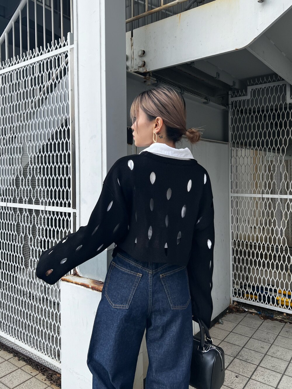 ブルー系のデニムパンツ、ホワイト系のローファー、ブラック系のニット/セーターを着用したレディースの冬コーディネートの6枚目の写真