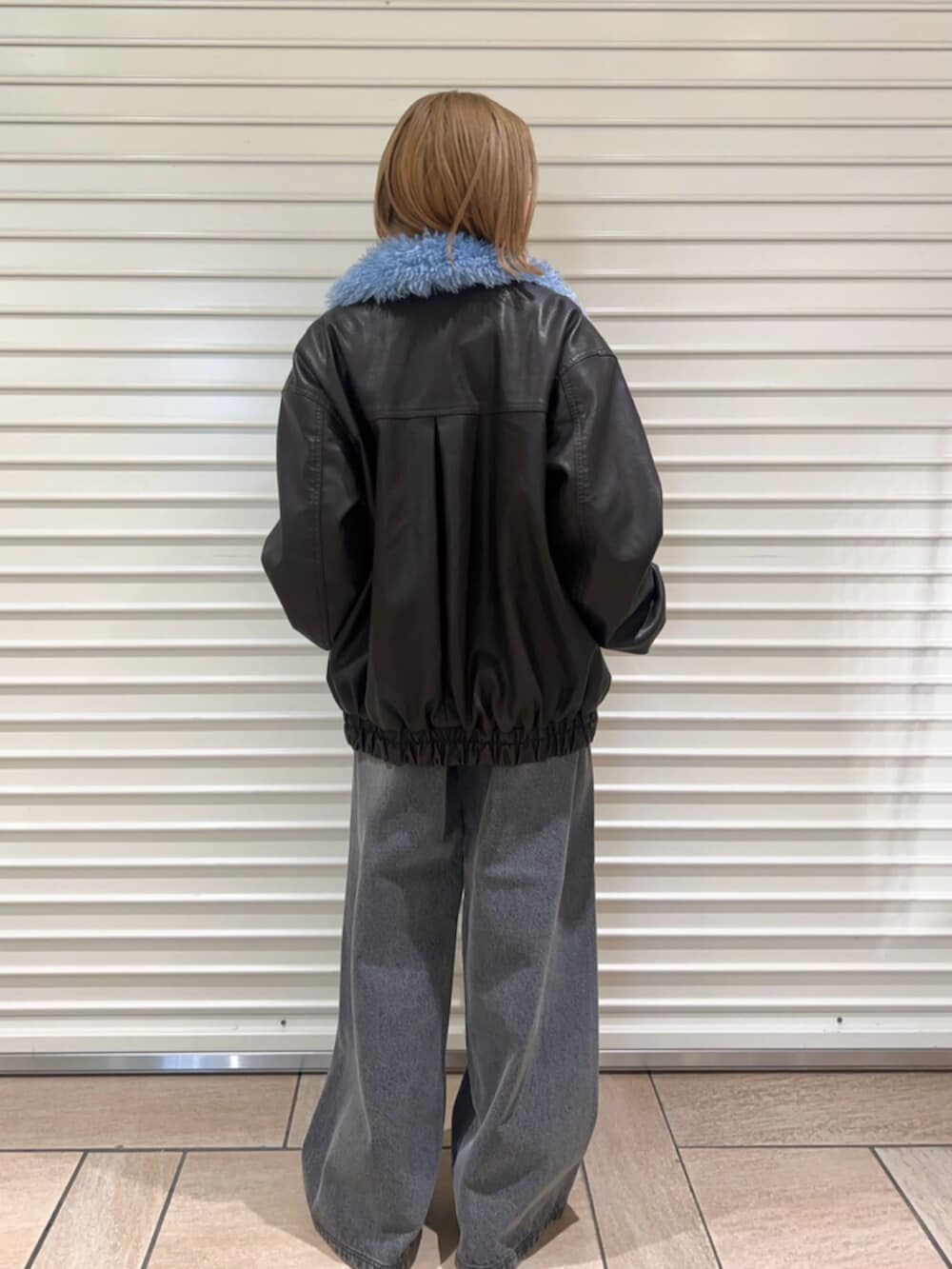 ブラック系のニット/セーター、ブラウン系のブルゾン、ブラック系のその他パンツを着用したレディースの冬コーディネートの3枚目の写真