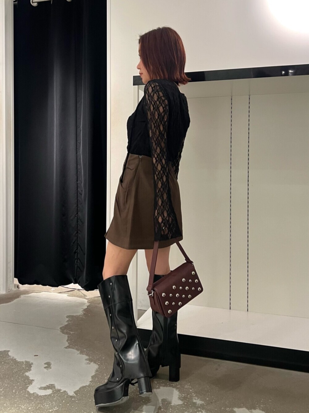 ブラック系のTシャツ/カットソー、ブラウン系のスカート、ブラック系のブーツを着用したレディースの秋コーディネートの3枚目の写真