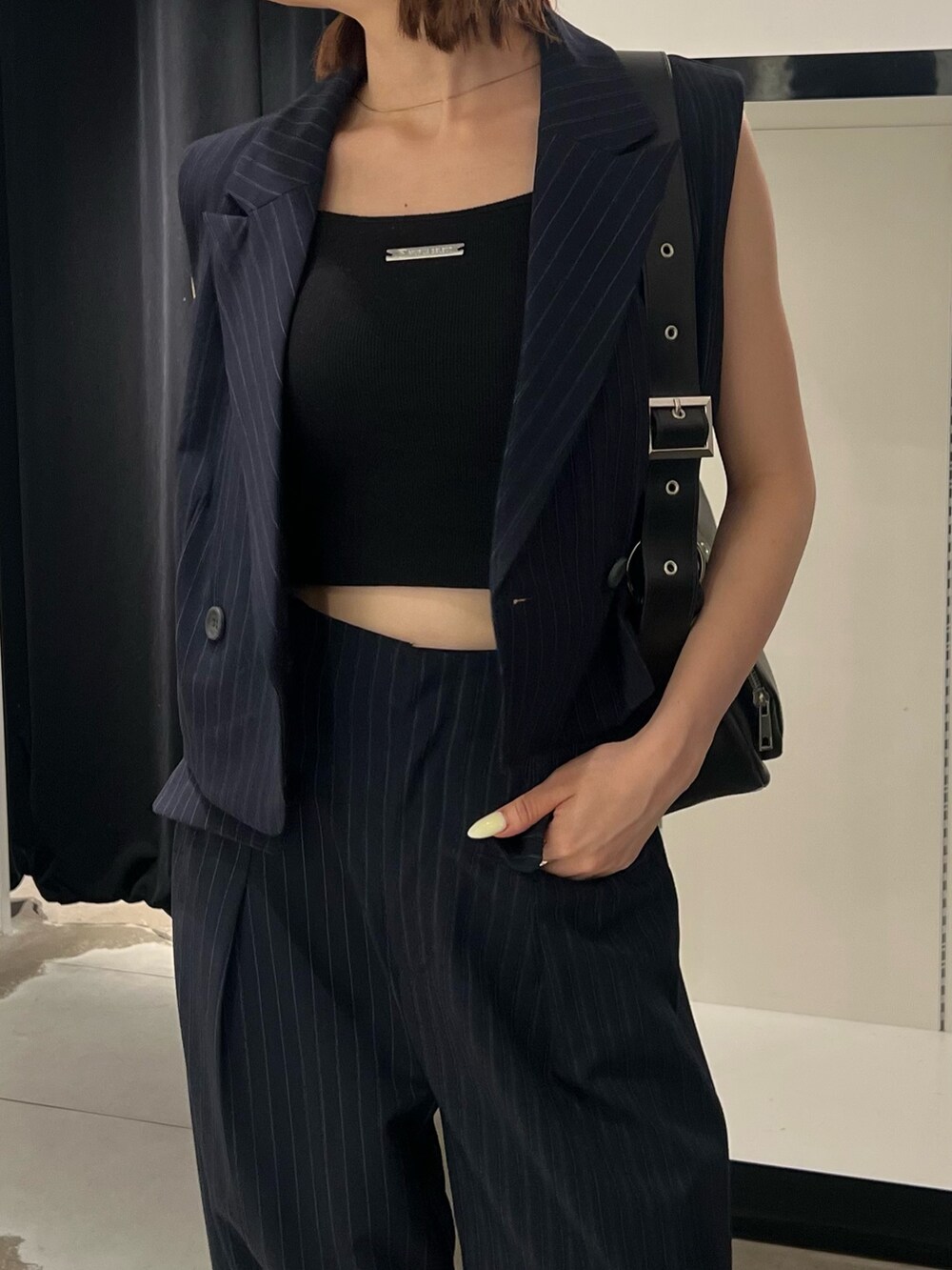 ブルー系のベスト、ブルー系のその他パンツ、ブラック系のキャミソールを着用したレディースの夏コーディネートの7枚目の写真