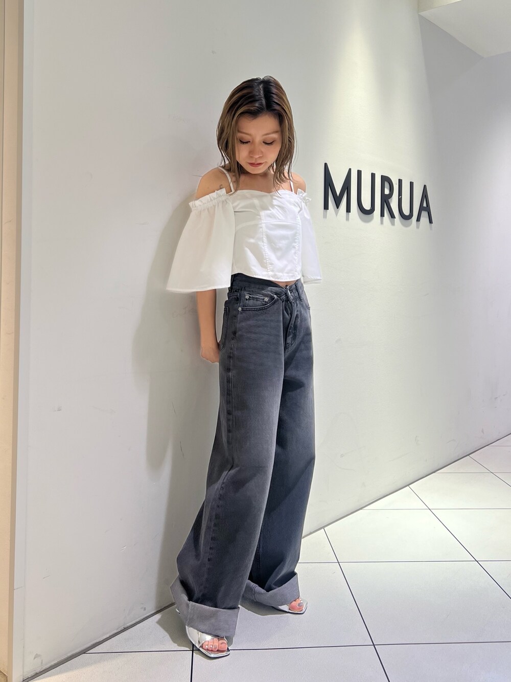 ブラック系のデニムパンツ、ホワイト系のシャツ/ブラウス、シルバー系のサンダルを着用したレディースの夏コーディネートの3枚目の写真