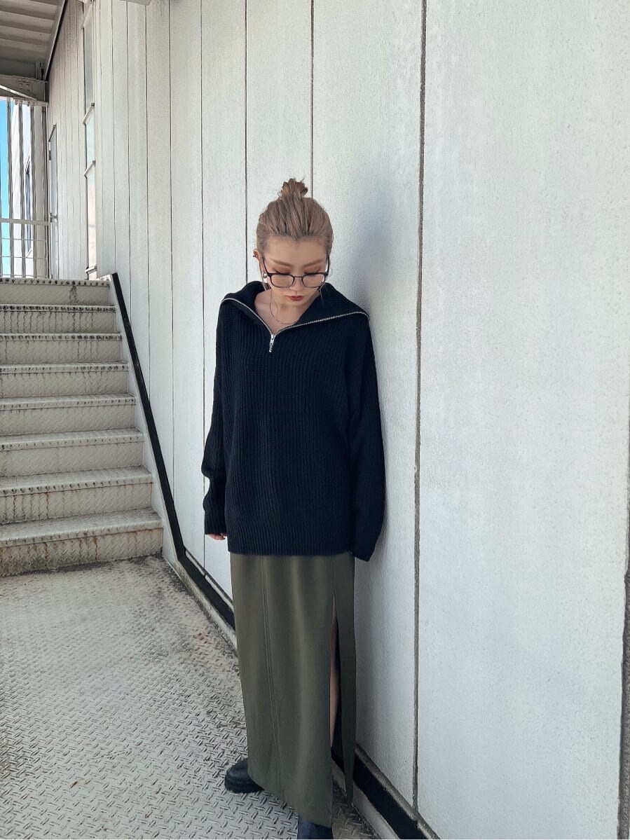 グリーン系のスカート、ブラック系のブーツ、ブラック系のニット/セーターを着用したレディースの秋コーディネートの4枚目の写真