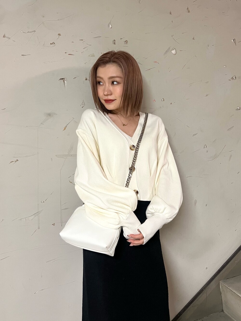 ホワイト系のブーツ、ブラック系のスカート、ホワイト系のカーディガン/ボレロを着用したレディースの冬コーディネートの4枚目の写真