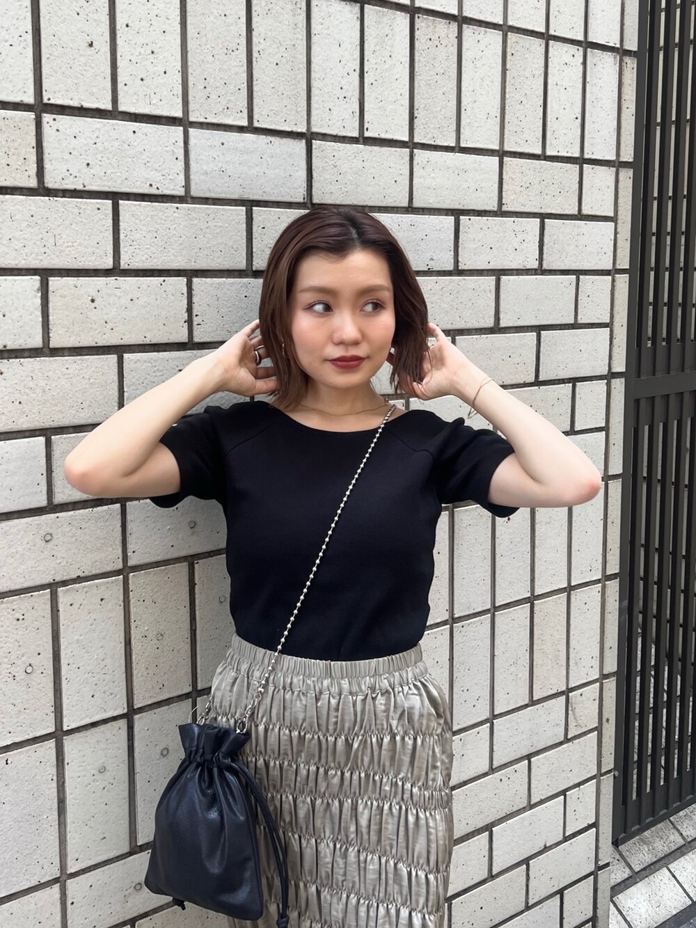 ブラック系のTシャツ/カットソー、グリーン系のスカート、ブラック系のショルダーバッグを着用したレディースの夏コーディネートの4枚目の写真