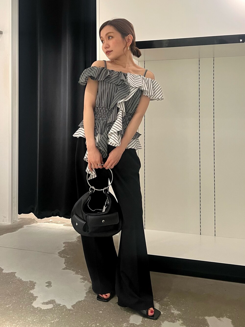 ブラック系のパンプス、ブラック系のハンドバッグ、ブラック系のその他パンツを着用したレディースの夏コーディネートの3枚目の写真