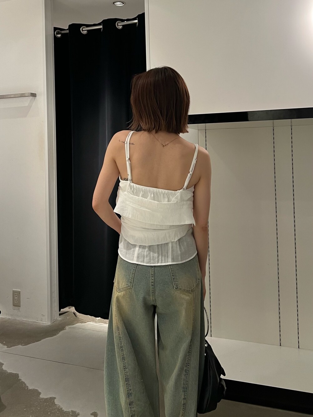 ホワイト系のシャツ/ブラウス、ブルー系のデニムパンツ、シルバー系のパンプスを着用したレディースの夏コーディネートの6枚目の写真