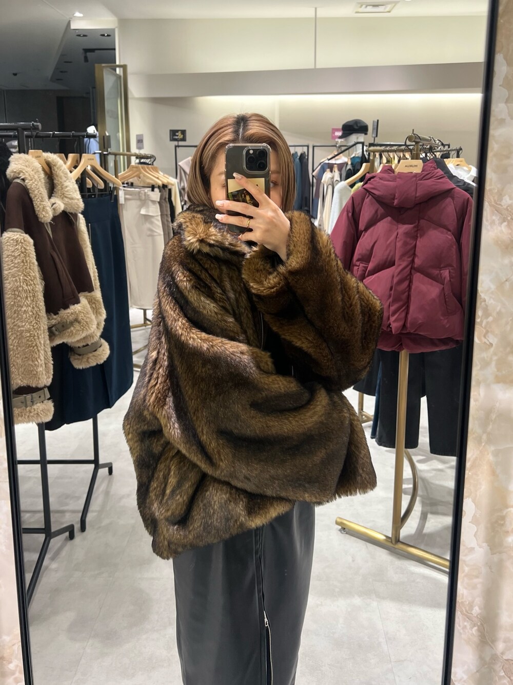 ブラック系のスカート、ブラウン系のブルゾン、ブラック系のニット/セーターを着用したレディースの冬コーディネートの4枚目の写真