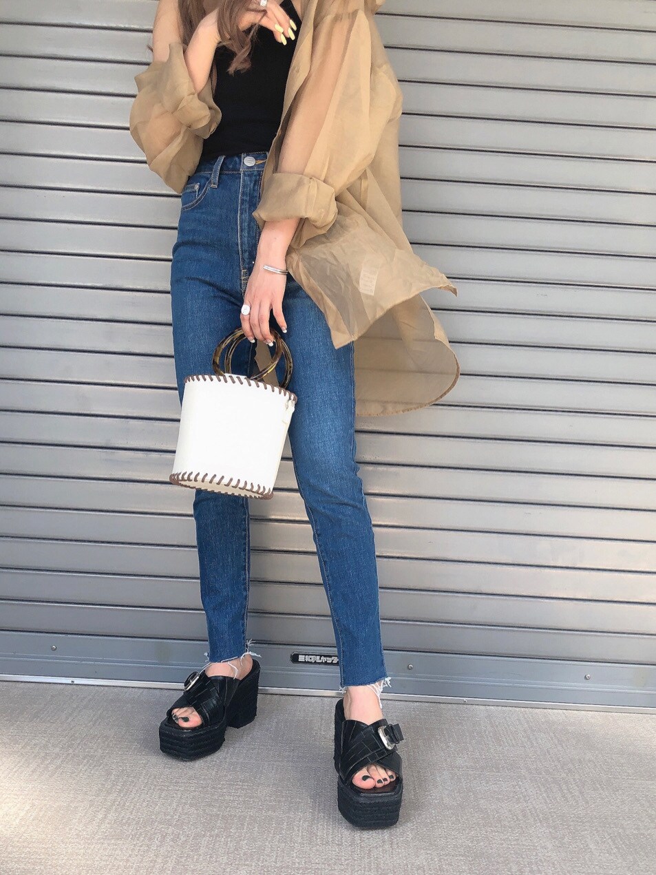 ブルー系のデニムパンツ、ブラウン系のシャツ/ブラウス、ブラック系のキャミソールを着用したレディースの春コーディネートの4枚目の写真