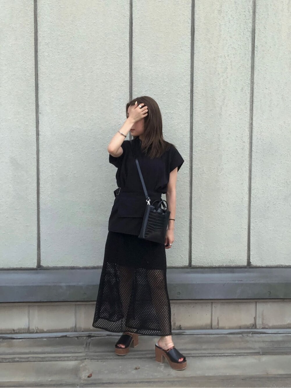 ブラック系のスカート、ブラック系のタンクトップ、ブラック系のショルダーバッグを着用したレディースの夏コーディネートの3枚目の写真