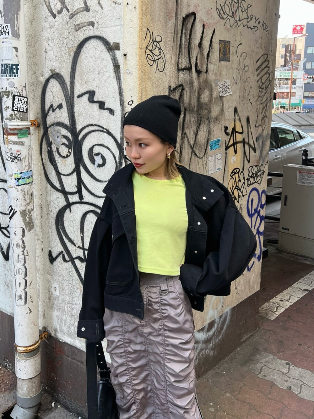 イエロー系のTシャツ/カットソー、ブラック系のデニムジャケット、グレー系のスカートを着用したレディースの春コーディネートの5枚目の写真