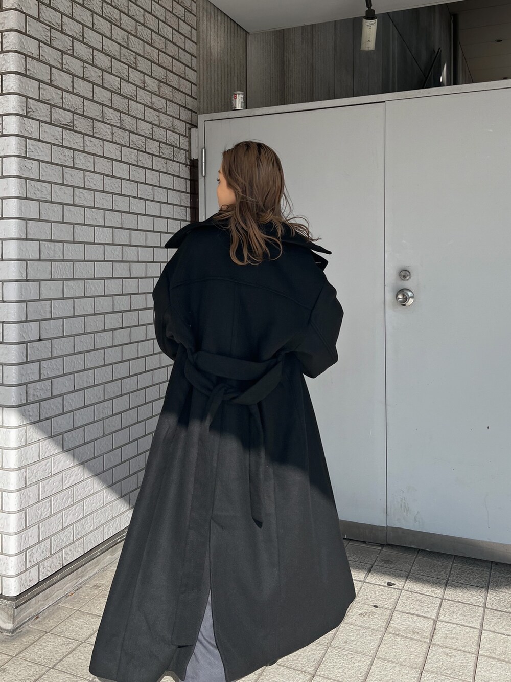 レッド系のニット/セーター、ブラック系のダウンジャケット/コート、ブラック系のブーツを着用したレディースの秋コーディネートの6枚目の写真