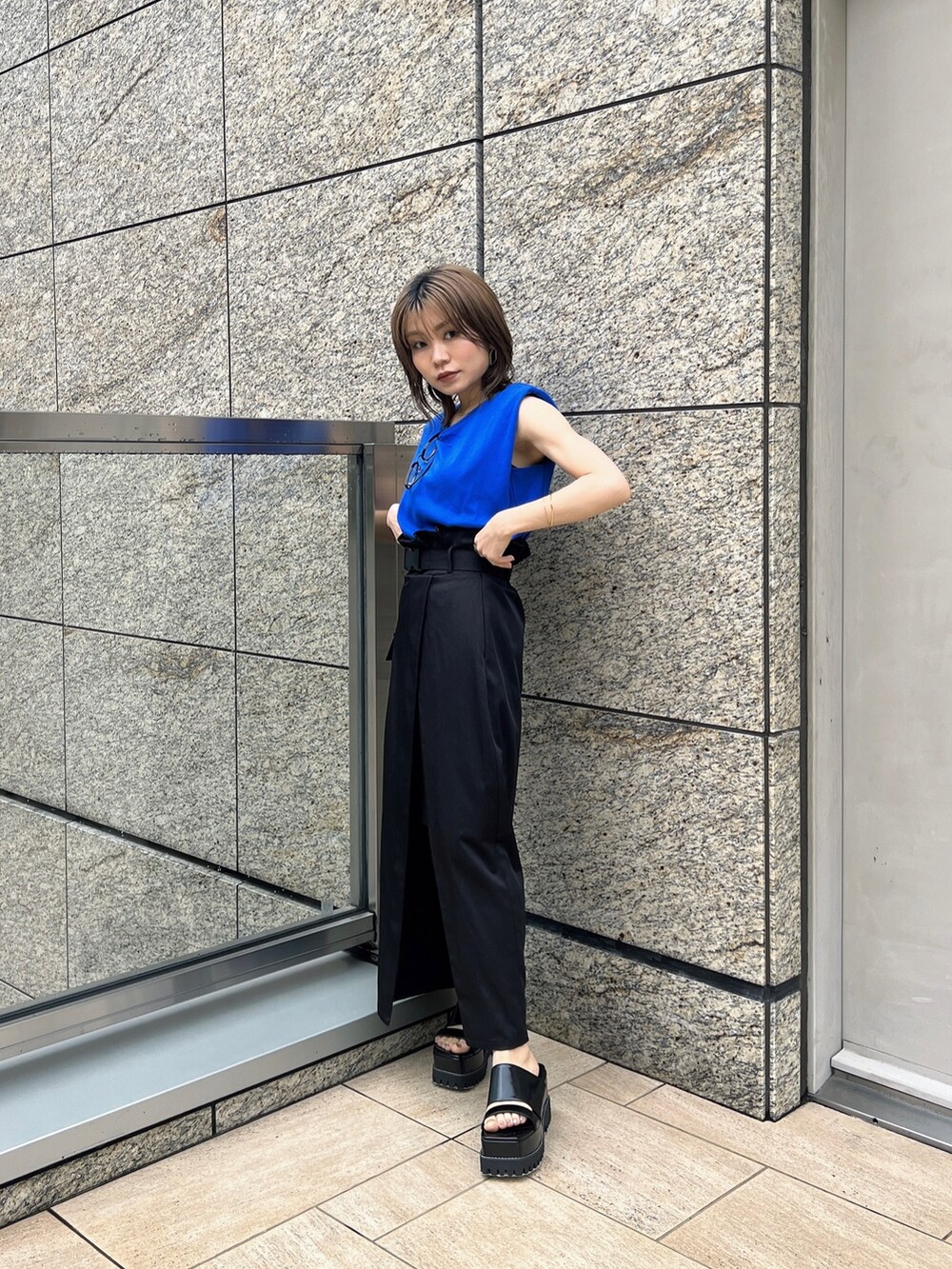 ブラック系のスカート、ブラック系のサンダル、ブルー系のTシャツ/カットソーを着用したレディースの夏コーディネートの2枚目の写真