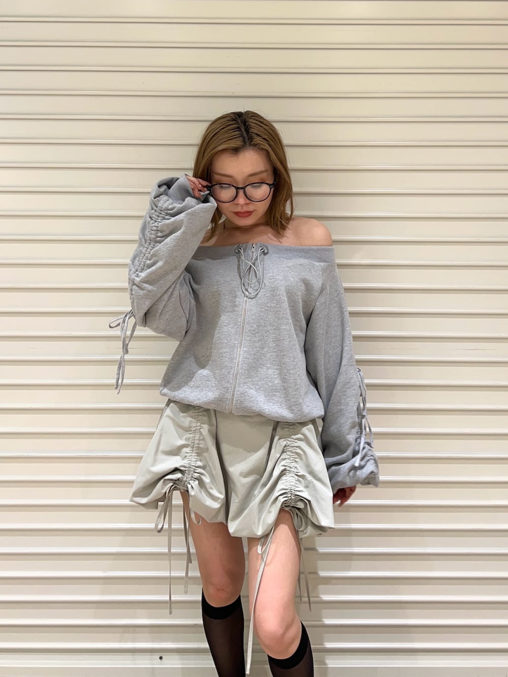 グリーン系のスカート、グレー系のスウェットを着用したレディースの春コーディネートの4枚目の写真