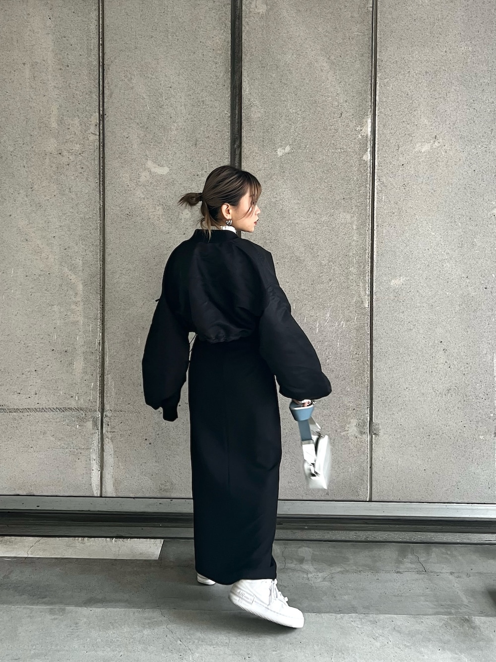 ブラック系のMA-1、ホワイト系のニット/セーター、ブラック系のスカートを着用したレディースの冬コーディネートの3枚目の写真