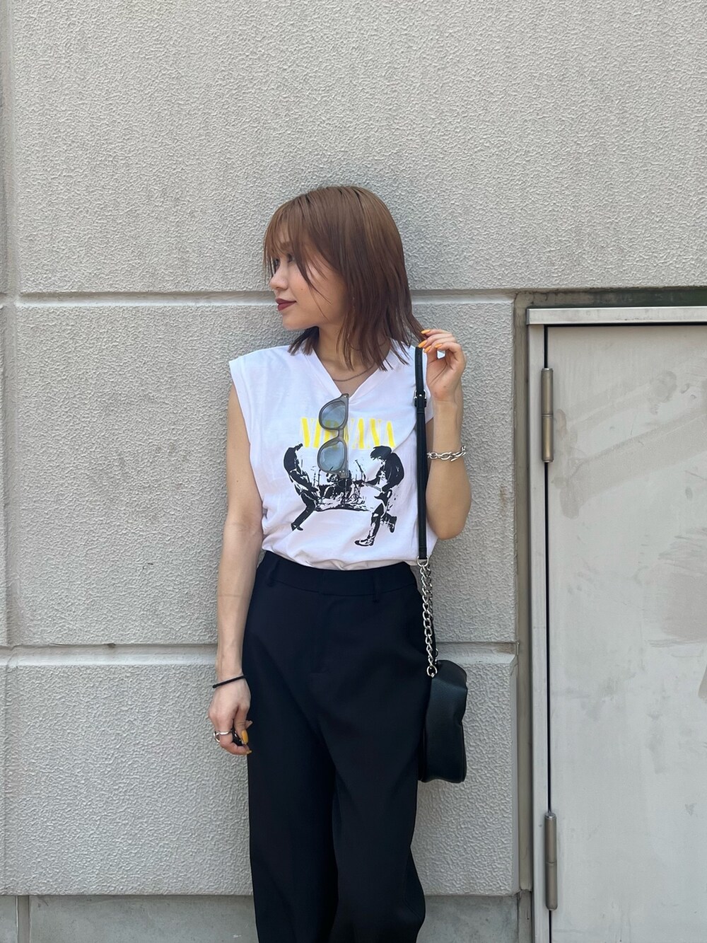 ホワイト系のタンクトップ、ブラック系のハンドバッグ、ブラック系のサンダルを着用したレディースの春コーディネートの6枚目の写真
