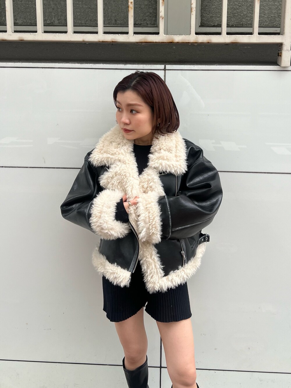 ブラック系のムートンコート、ブラック系のニット/セーター、ブラック系のその他パンツを着用したレディースの秋コーディネートの5枚目の写真