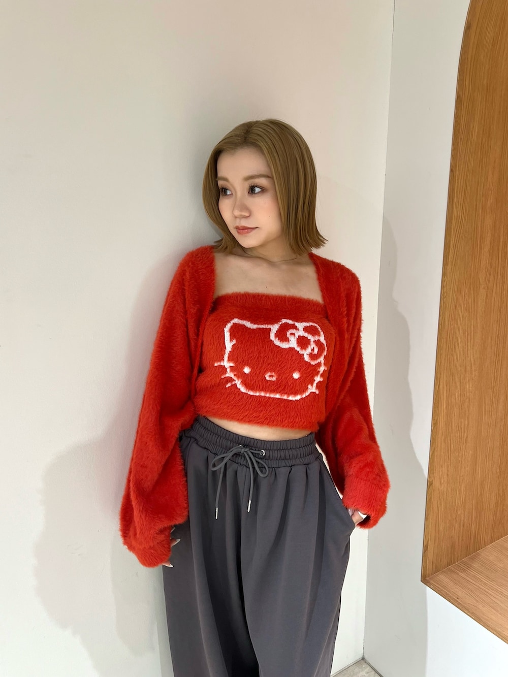 レッド系のニット/セーター、グレー系のその他パンツを着用したレディースの冬コーディネートの4枚目の写真