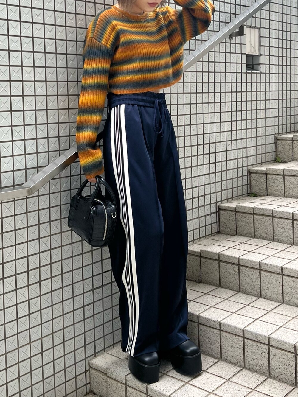 パープル系のカーディガン/ボレロ、ブラック系のブーツ、ブルー系のその他パンツを着用したレディースの秋コーディネートの8枚目の写真