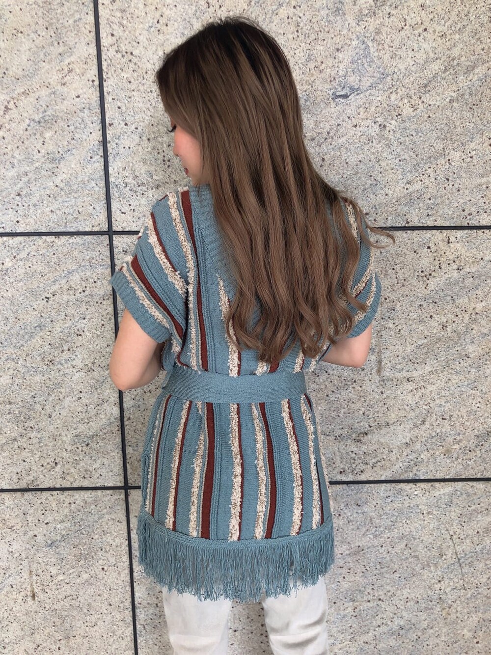 ブラック系のサンダル、ブルー系のニット/セーター、グレー系のデニムパンツを着用したレディースの夏コーディネートの4枚目の写真