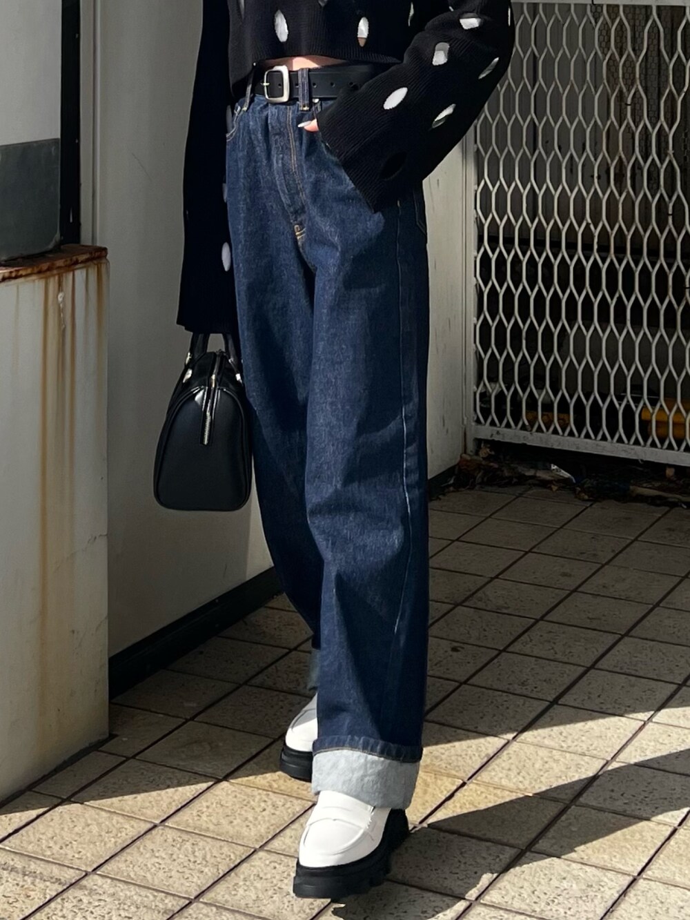 ブルー系のデニムパンツ、ホワイト系のローファー、ブラック系のニット/セーターを着用したレディースの冬コーディネートの8枚目の写真