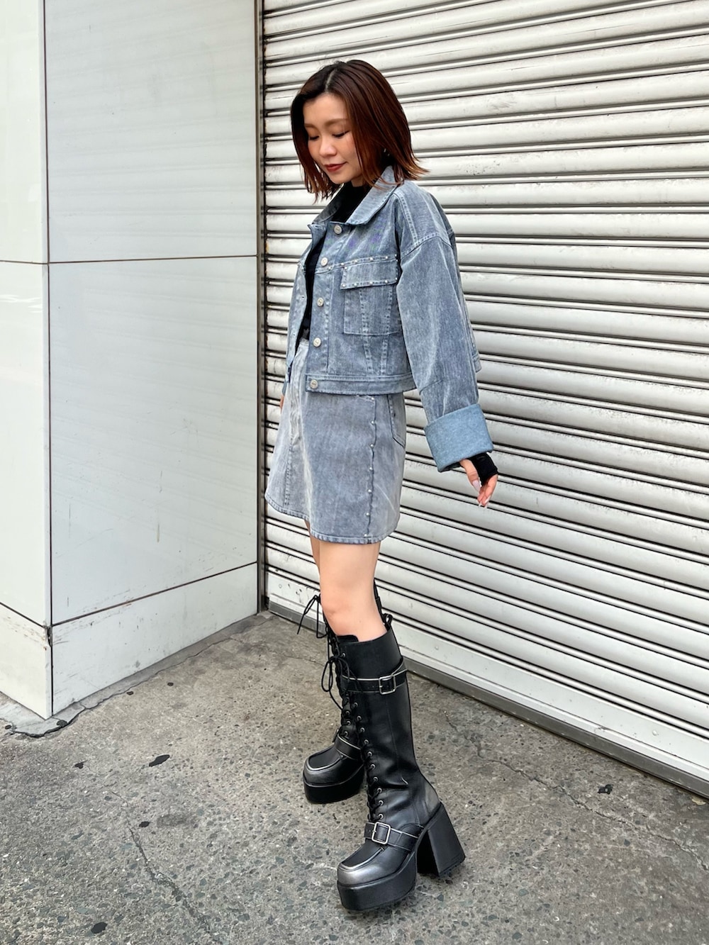 ブラック系のブーツ、ブラック系のTシャツ/カットソー、グレー系のデニムジャケットを着用したレディースの夏コーディネートの2枚目の写真