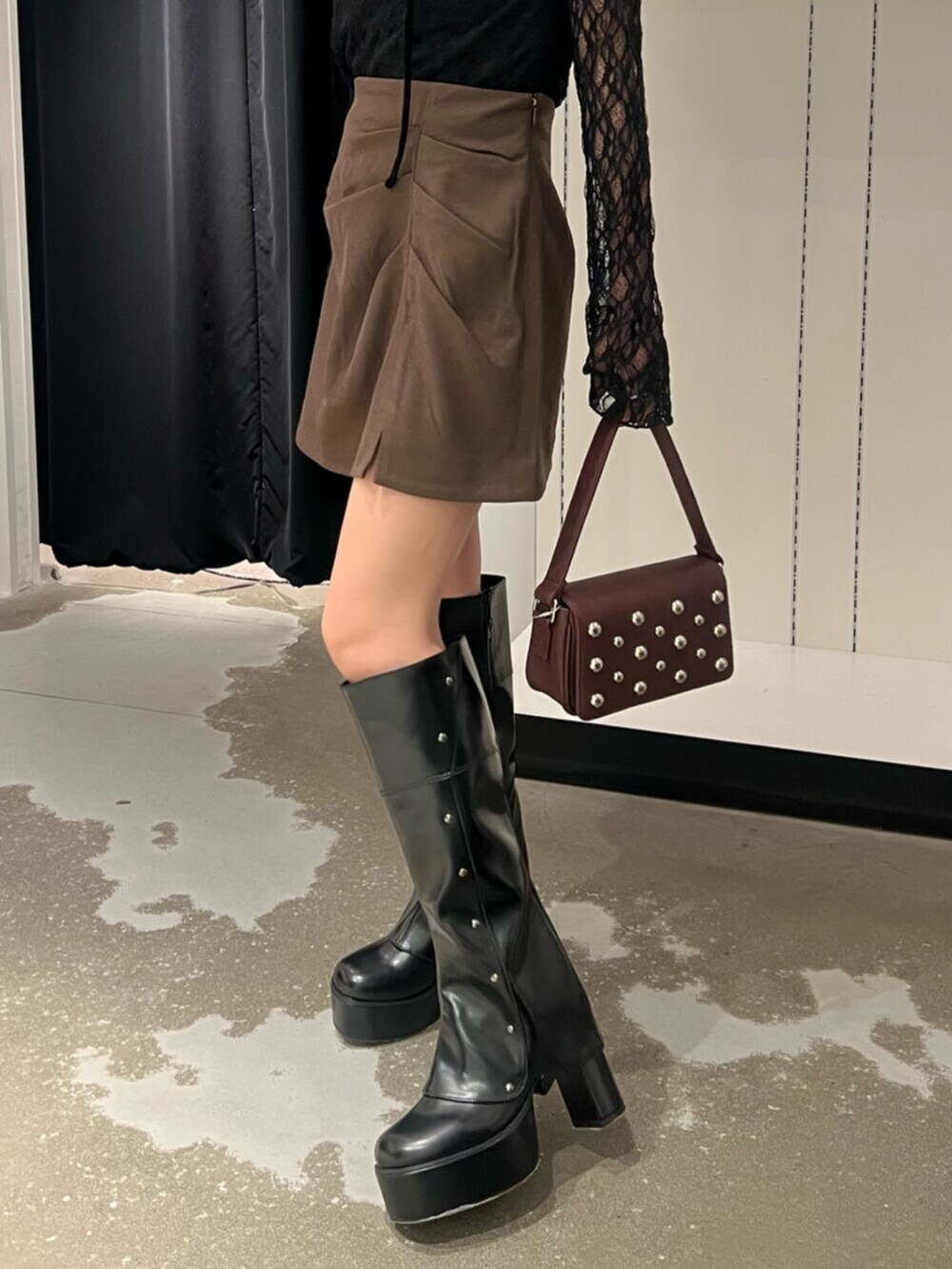 ブラック系のTシャツ/カットソー、ブラウン系のスカート、ブラック系のブーツを着用したレディースの秋コーディネートの8枚目の写真