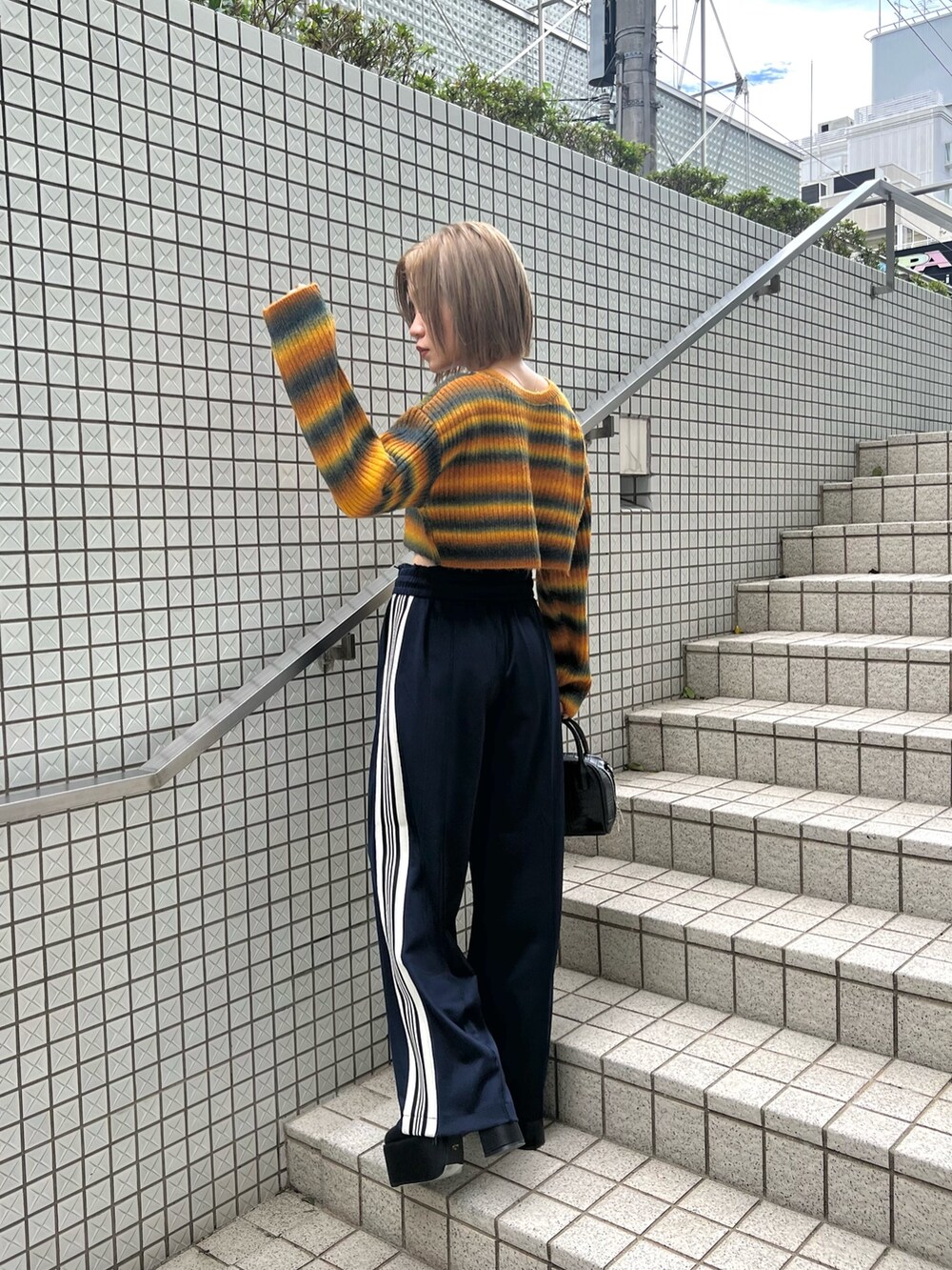 パープル系のカーディガン/ボレロ、ブラック系のブーツ、ブルー系のその他パンツを着用したレディースの秋コーディネートの3枚目の写真