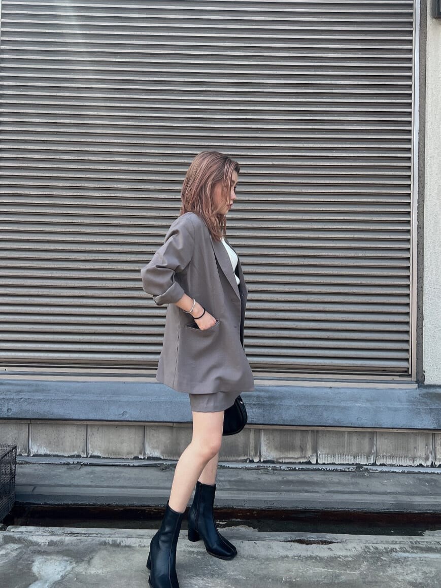 ホワイト系のタンクトップ、グレー系のテーラードジャケット、グレー系のスカートを着用したレディースの夏コーディネートの3枚目の写真