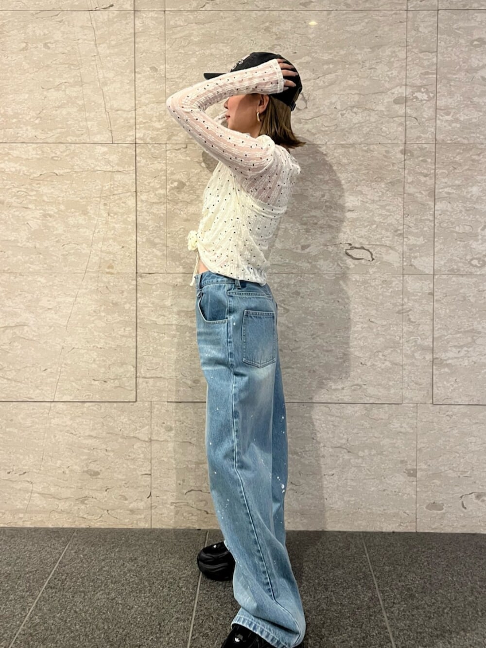 ホワイト系のTシャツ/カットソー、ブルー系のデニムパンツ、ブラック系のキャップを着用したレディースの春コーディネートの2枚目の写真