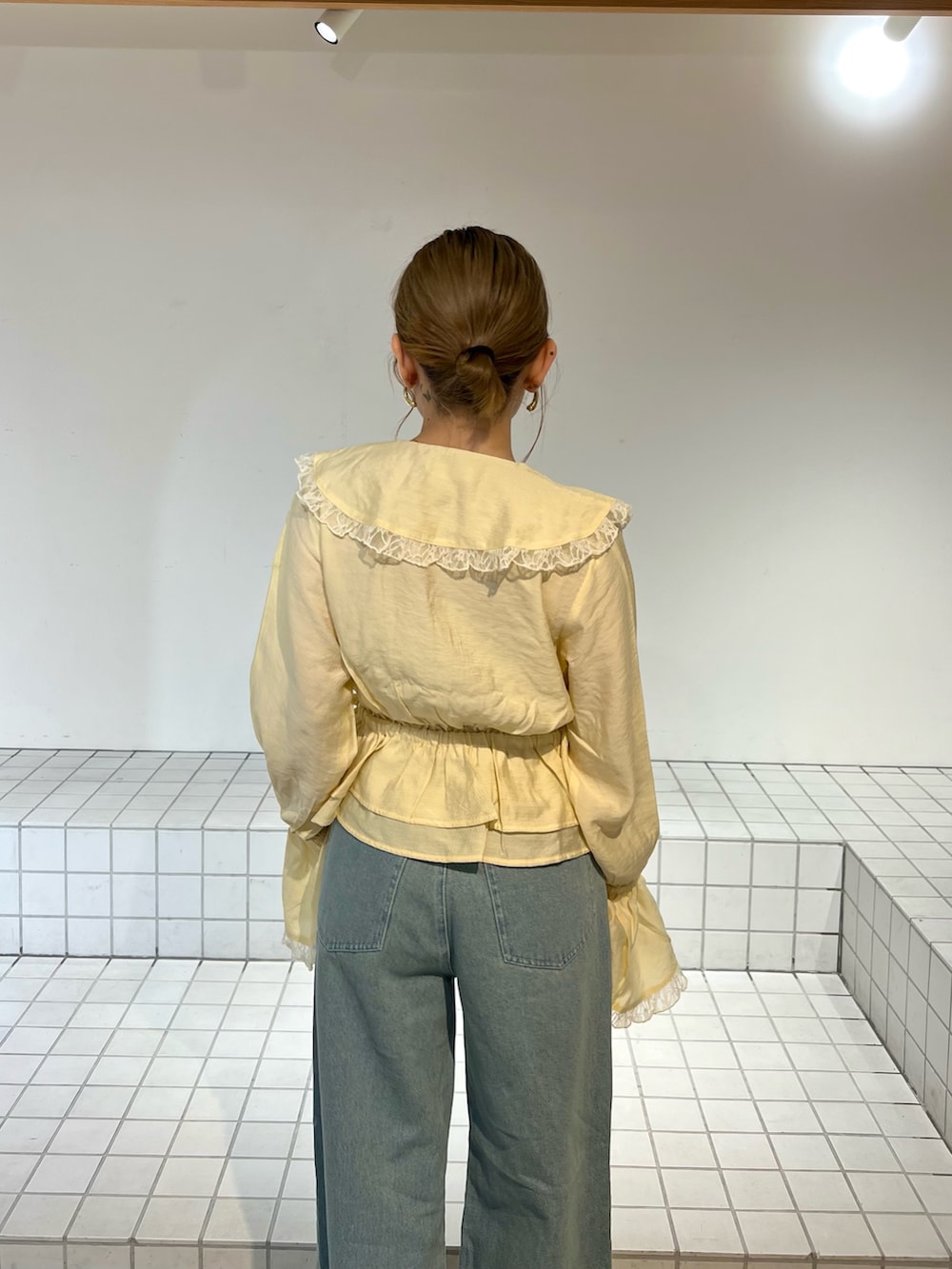 ブルー系のデニムパンツ、イエロー系のシャツ/ブラウス、ブラック系のサンダルを着用したレディースの春コーディネートの5枚目の写真