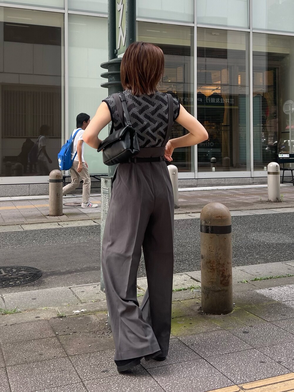 ブラック系のニット/セーター、グレー系のその他パンツ、ブラック系のハンドバッグを着用したレディースの夏コーディネートの2枚目の写真