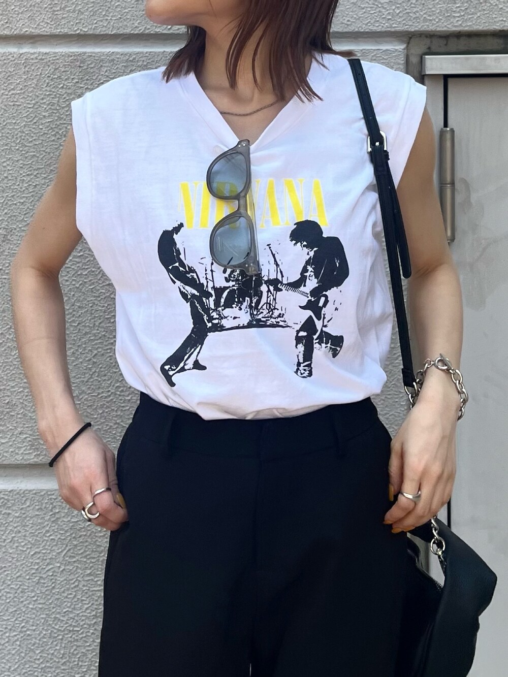 ホワイト系のタンクトップ、ブラック系のハンドバッグ、ブラック系のサンダルを着用したレディースの春コーディネートの7枚目の写真