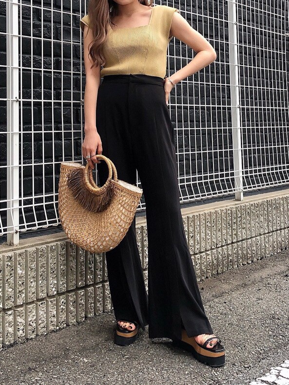 ブラック系のスラックス、ベージュ系のかごバッグ、ブラック系のサンダルを着用したレディースの夏コーディネートの4枚目の写真