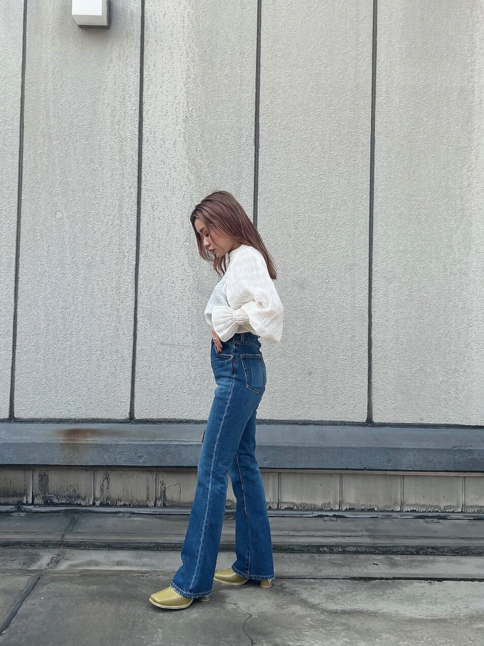 ブルー系のデニムパンツ、ホワイト系のシャツ/ブラウス、ブラック系のハンドバッグを着用したレディースの夏コーディネートの3枚目の写真