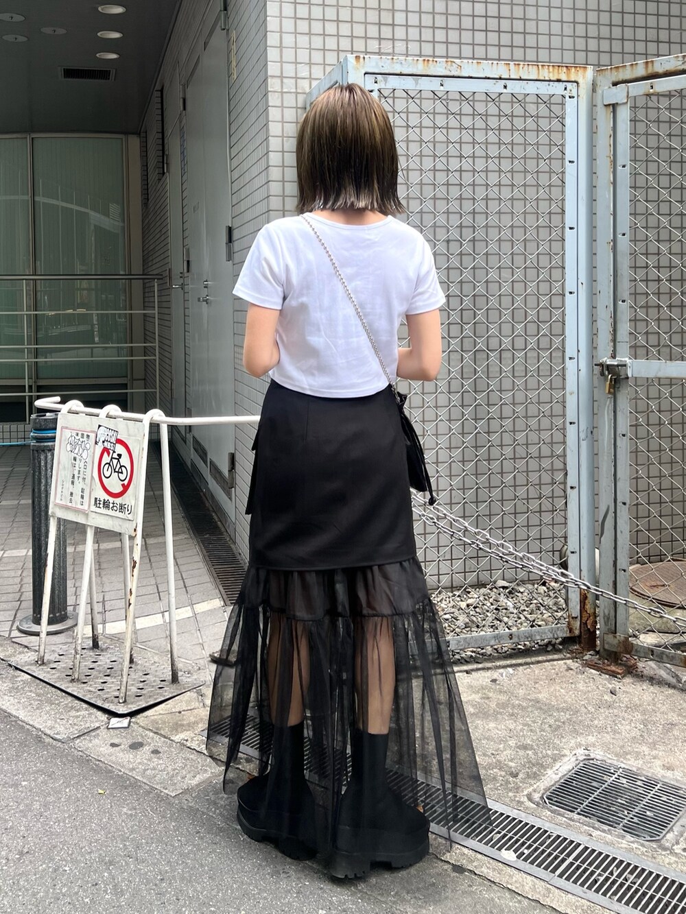 ホワイト系のTシャツ/カットソー、ブラック系のスカート、ブラック系のショルダーバッグを着用したレディースの春コーディネートの4枚目の写真