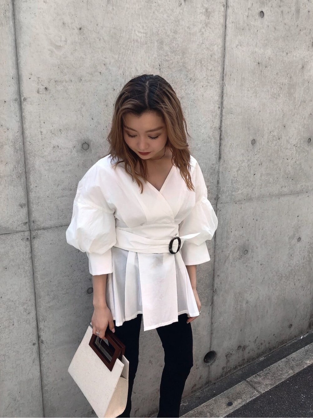 ホワイト系のサンダル、ブラック系のデニムパンツ、ホワイト系のハンドバッグを着用したレディースの春コーディネートの4枚目の写真